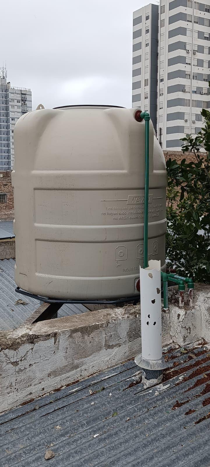 Tanque de agua instalado sobre un techo de chapa